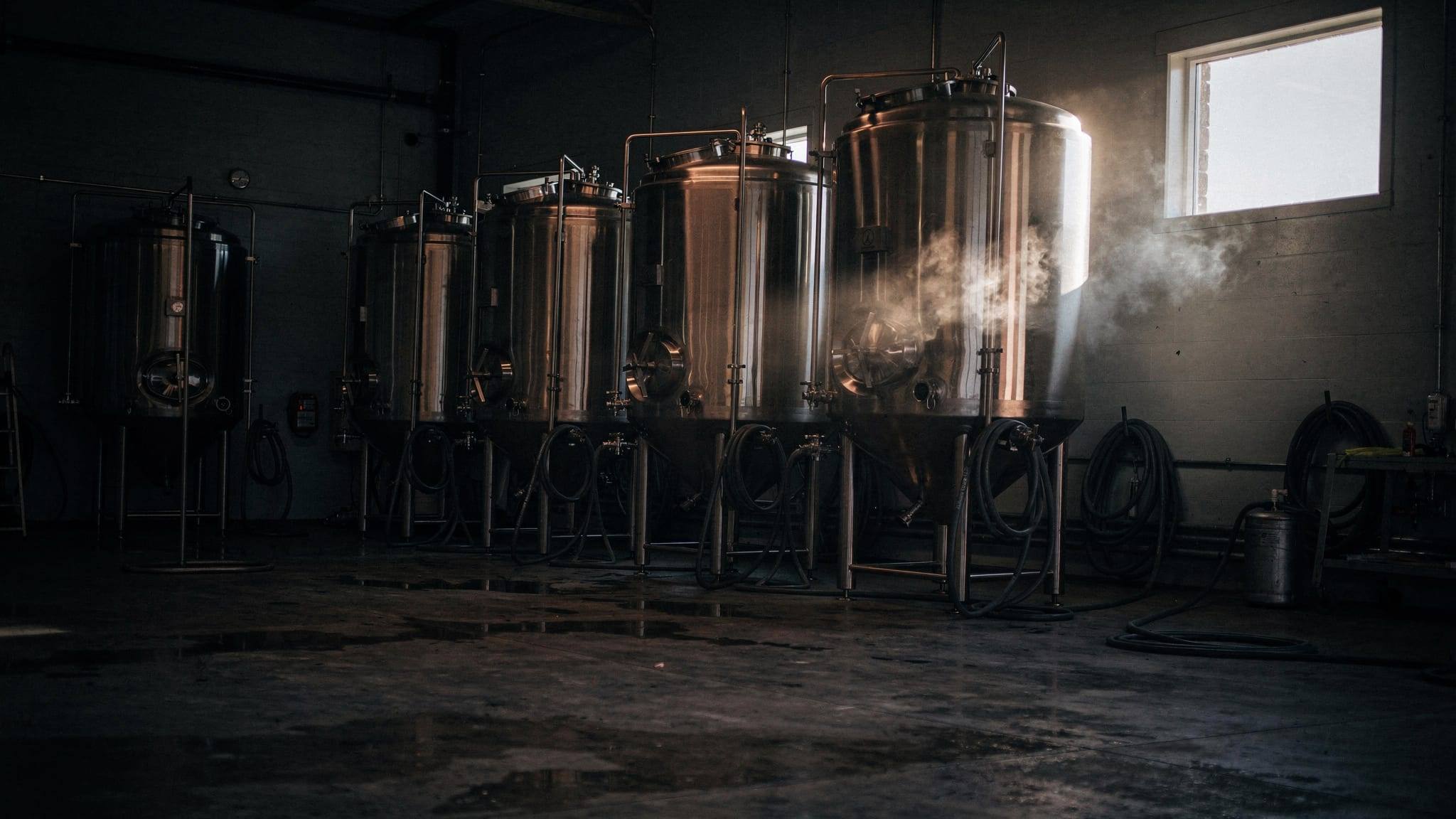 An empty, freshly cleaned brewhouse at dawn, with no one on the floor.