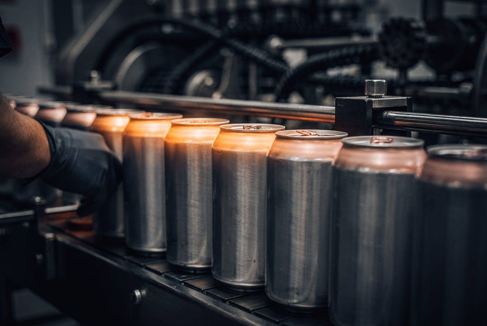Close-up of cans moving along a packaging line.